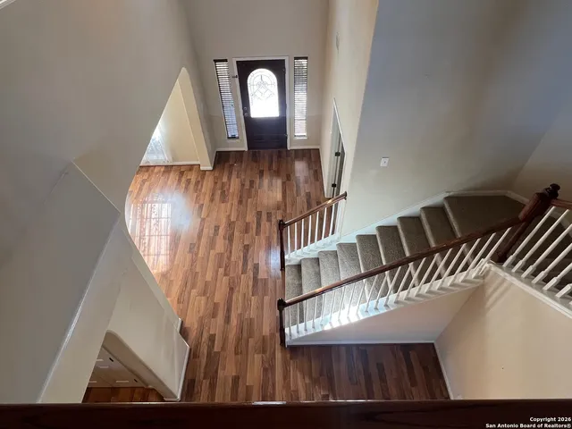 a view of staircase with wooden floor and fan