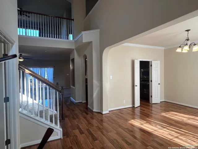 a view of a hallway with wooden floor and staircase