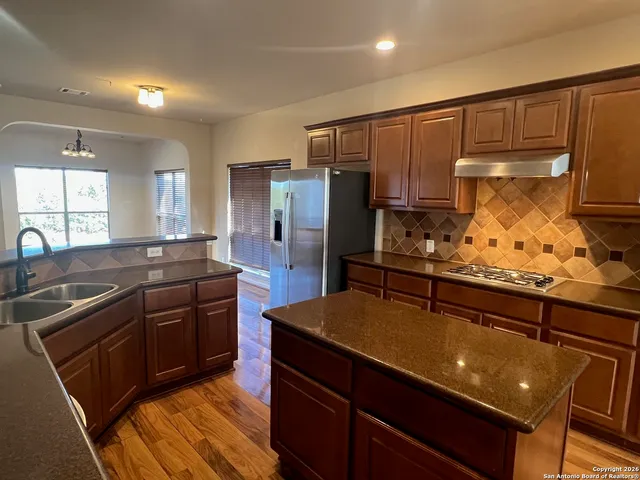 a kitchen with granite countertop stainless steel appliances and wooden cabinets