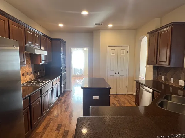 a kitchen with stainless steel appliances granite countertop a stove a sink and a refrigerator