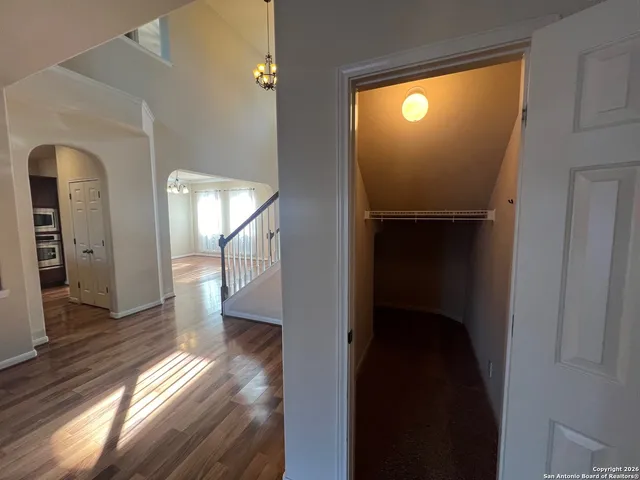 a view of empty room with wooden floor and fan