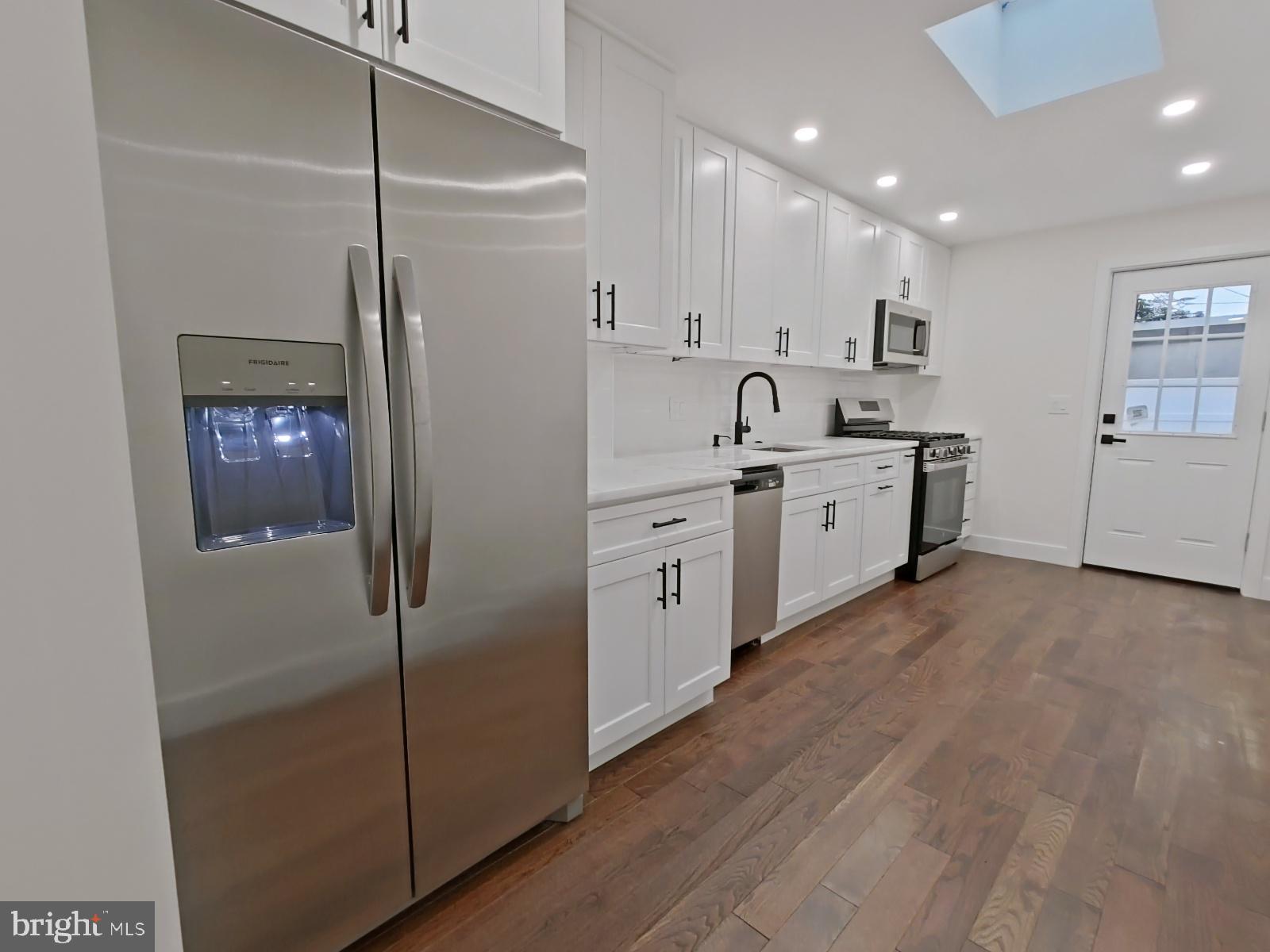 1307 North Randolph Street Philadelphia, PA 19122 - Photo 3 of 43 a kitchen with white cabinets and white appliances
