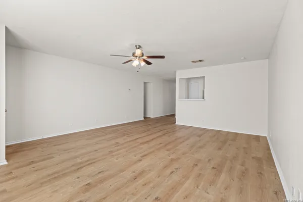 a view of a room with wooden floor and ceiling fan