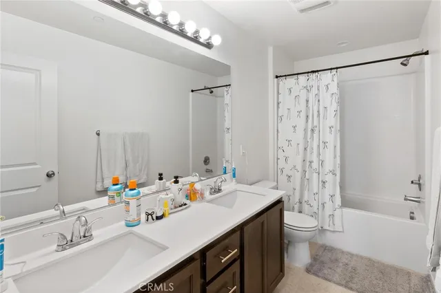 a bathroom with a double vanity sink mirror double and toilet