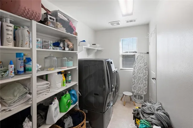 a view of walk in closet with clothes and shoes