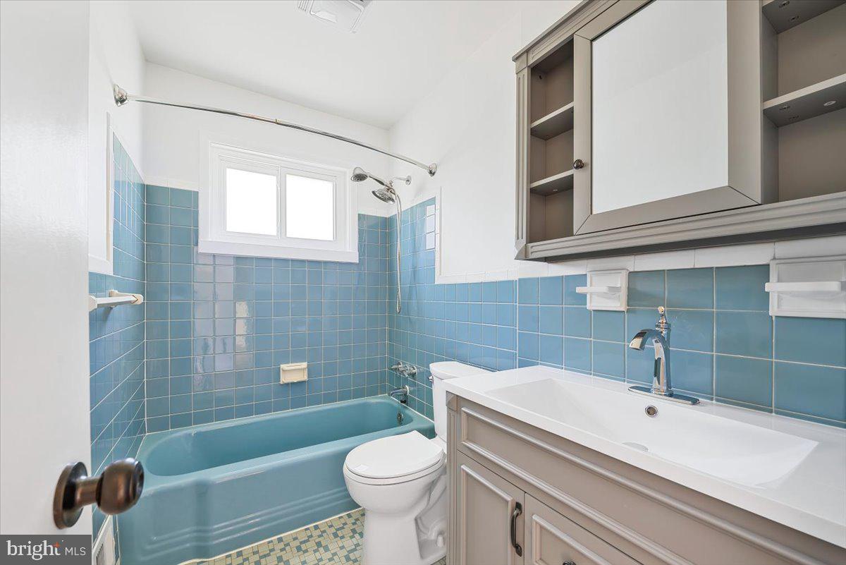 9619 Singleton Drive Bethesda, MD 20817 - Photo 11 of 25 a bathroom with a sink a toilet a mirror and bathtub