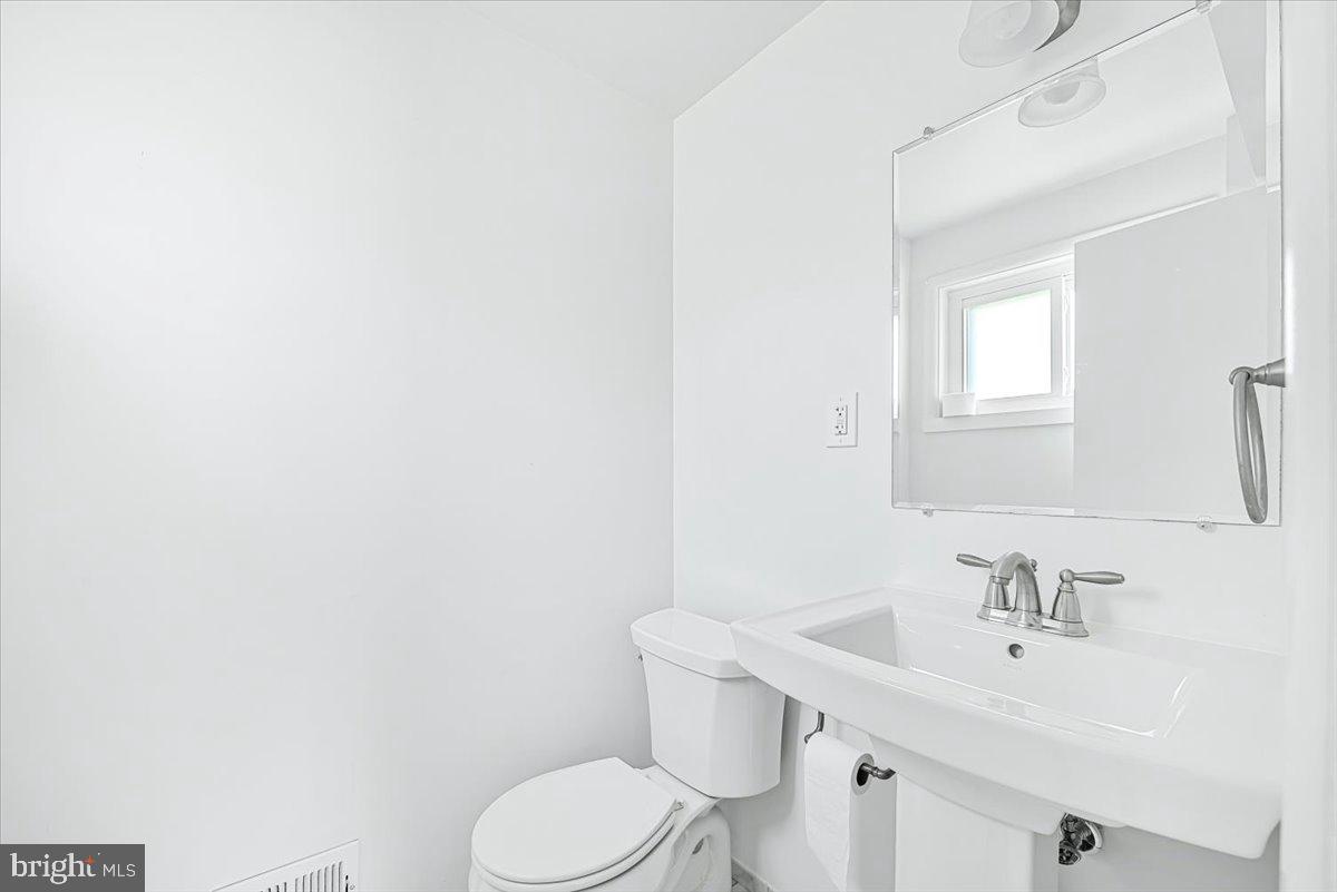9619 Singleton Drive Bethesda, MD 20817 - Photo 13 of 25 a bathroom with a sink a toilet and mirror