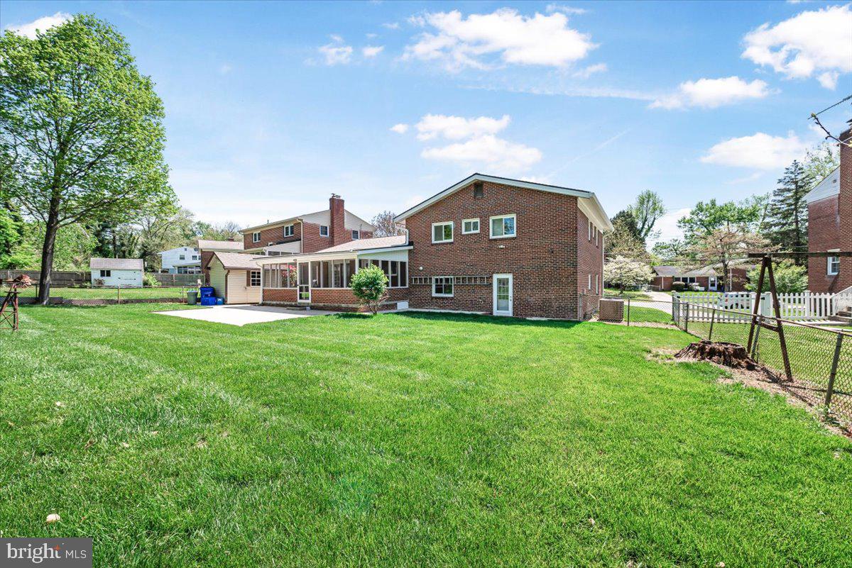 9619 Singleton Drive Bethesda, MD 20817 - Photo 19 of 25 a front view of a house with a big yard and large trees