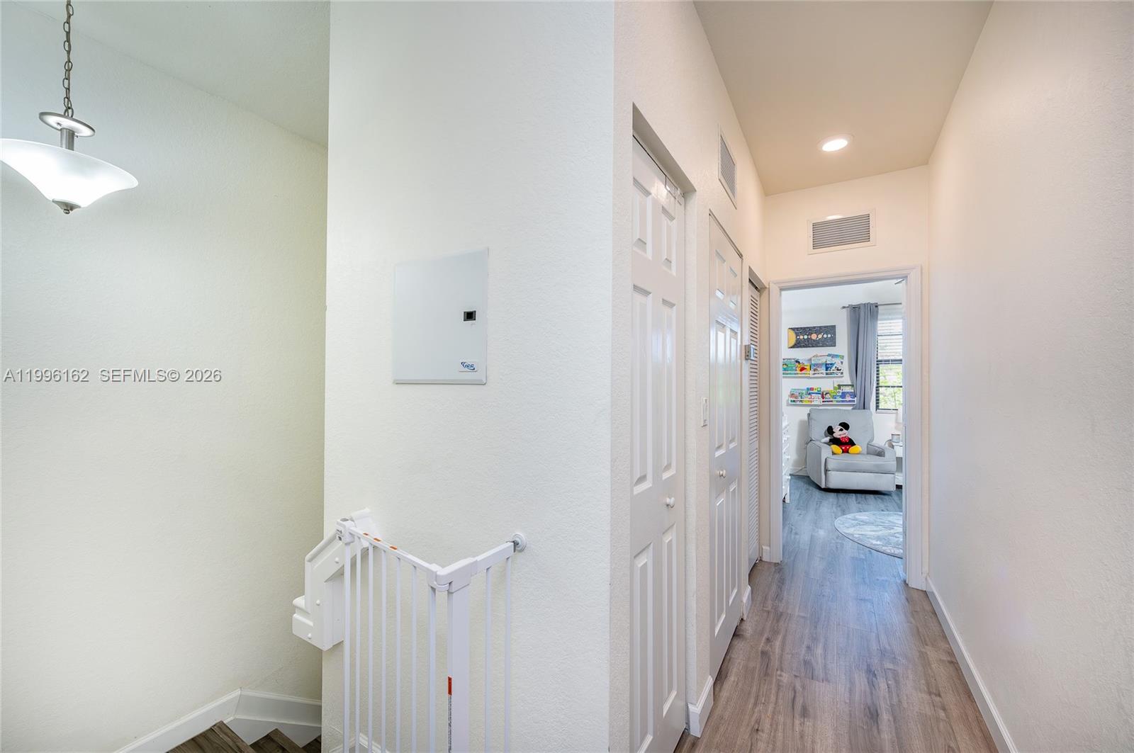 24951 Southwest 114th Court Homestead, FL 33032 - Photo 11 of 28 a view of a hallway with wooden floor and a bathroom