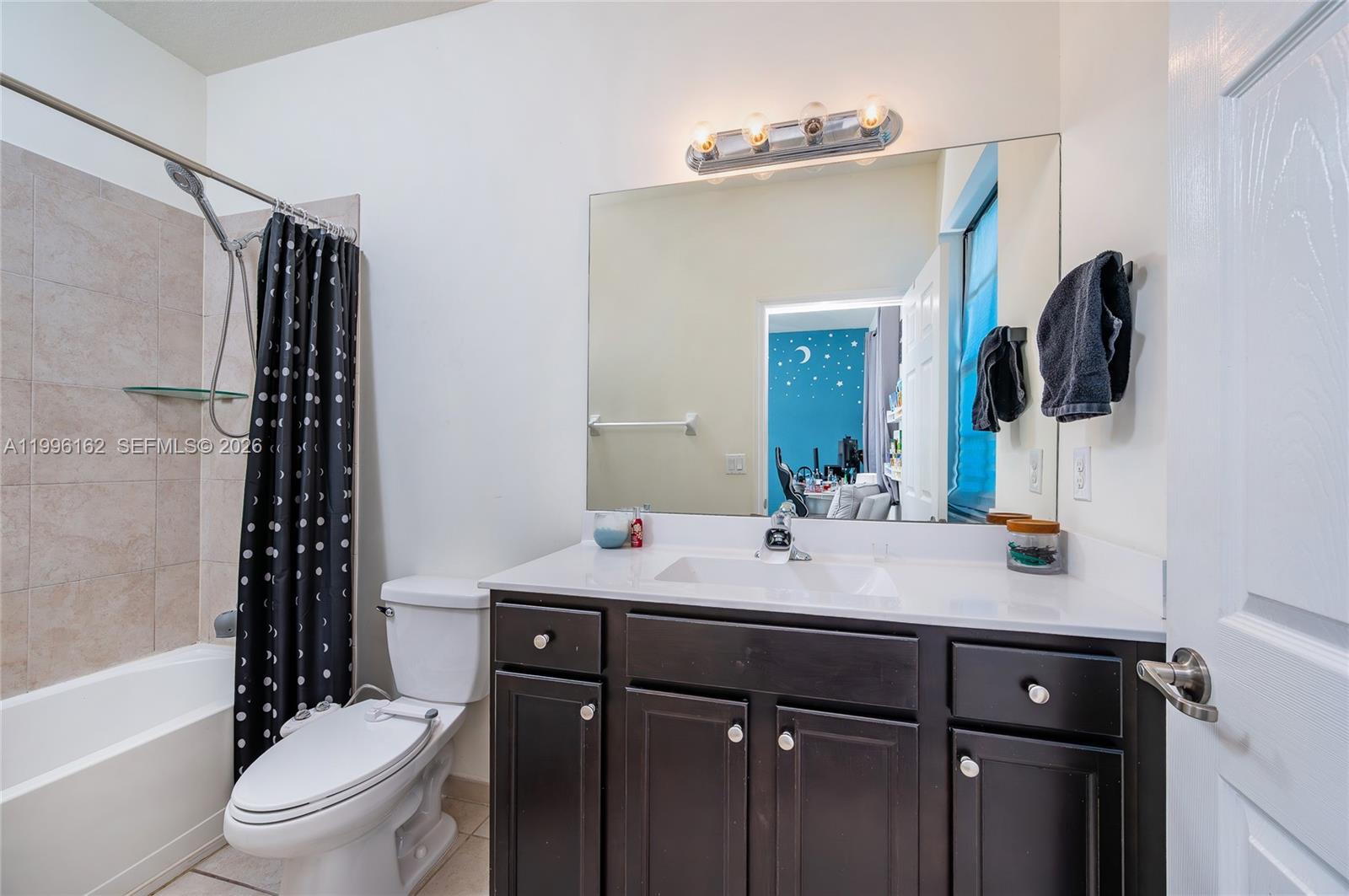 24951 Southwest 114th Court Homestead, FL 33032 - Photo 15 of 28 a bathroom with a sink a toilet a mirror a vanity and shower