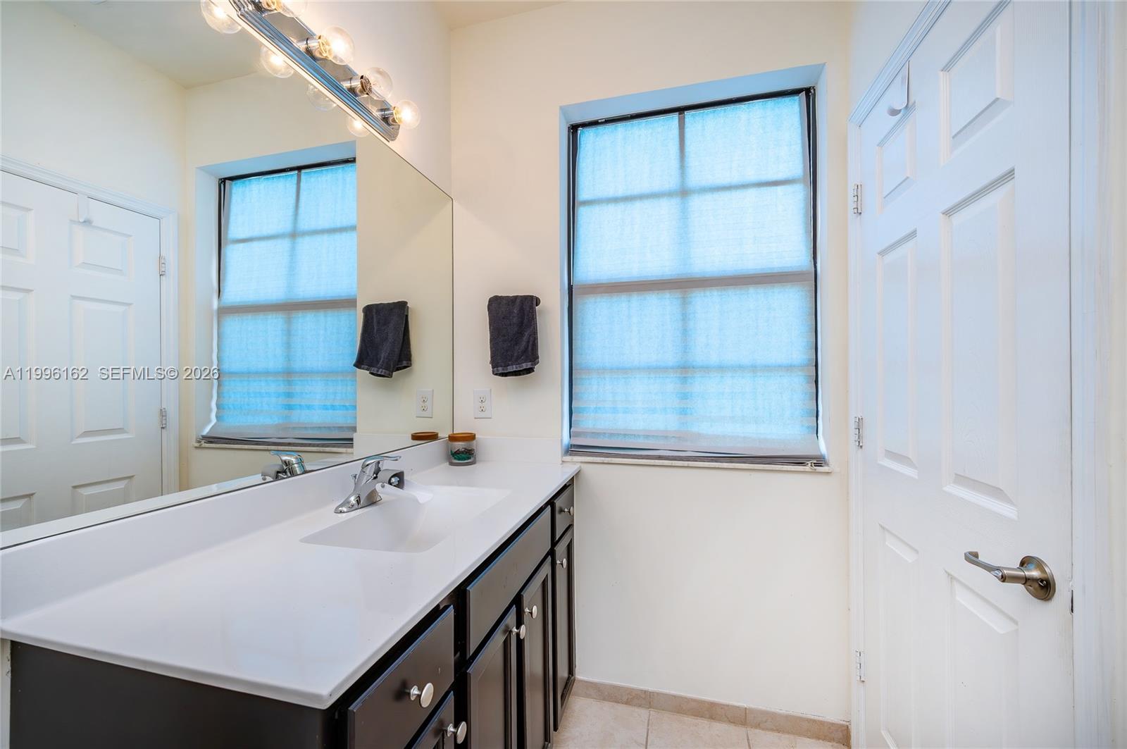 24951 Southwest 114th Court Homestead, FL 33032 - Photo 16 of 28 a bathroom with a sink and a mirror