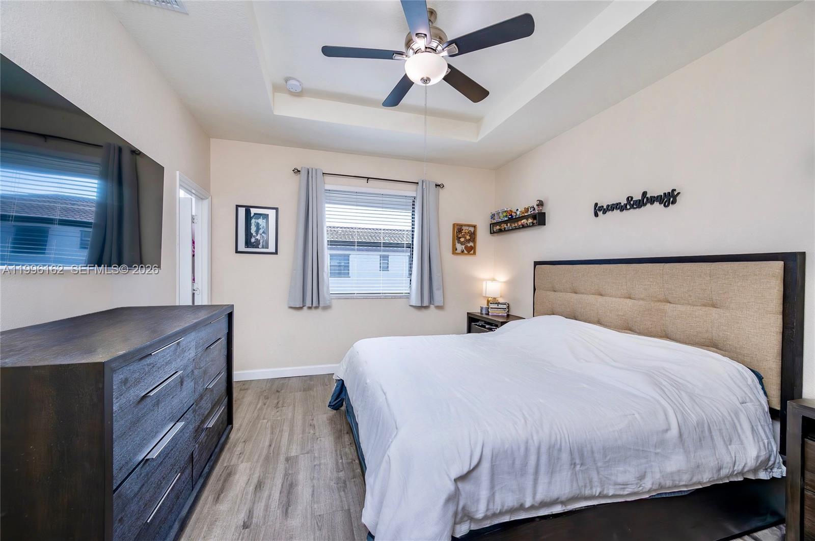 24951 Southwest 114th Court Homestead, FL 33032 - Photo 17 of 28 a bedroom with a large bed and a chandelier