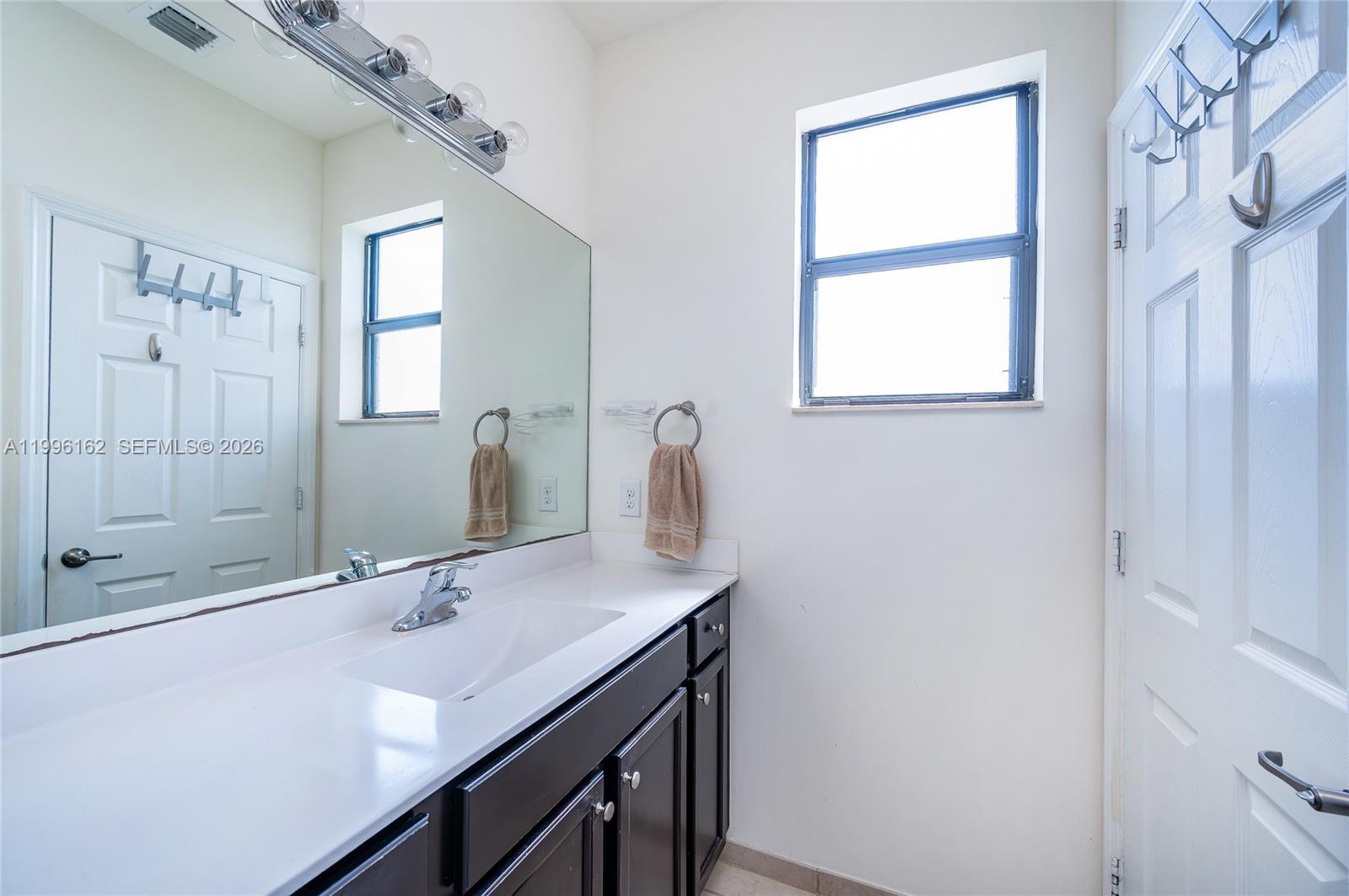 24951 Southwest 114th Court Homestead, FL 33032 - Photo 20 of 28 a bathroom with a sink a vanity and a mirror