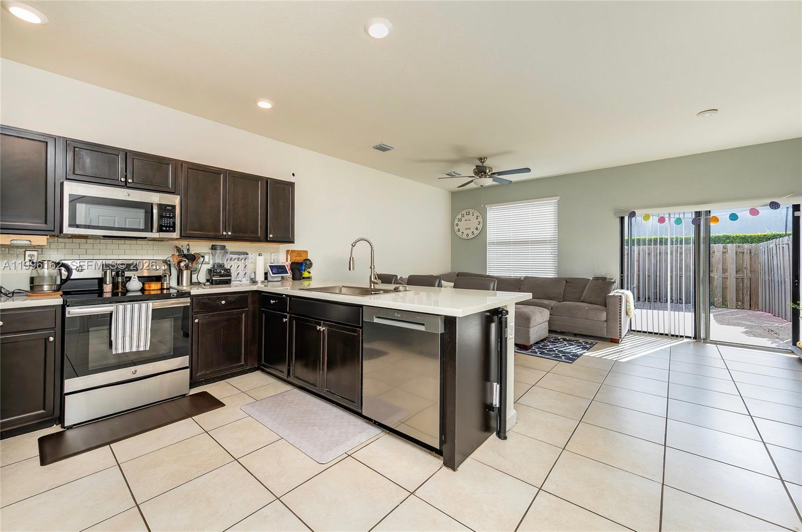 24951 Southwest 114th Court Homestead, FL 33032 - Photo 5 of 28 a kitchen with stainless steel appliances granite countertop a stove top oven a sink a counter top space and cabinets
