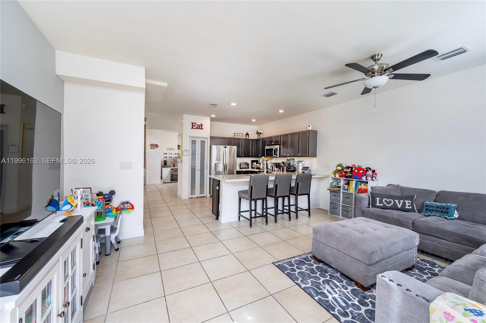 24951 Southwest 114th Court Homestead, FL 33032 - Photo 9 of 28 a living room with furniture and a flat screen tv