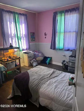 a bedroom with a bed and large windows
