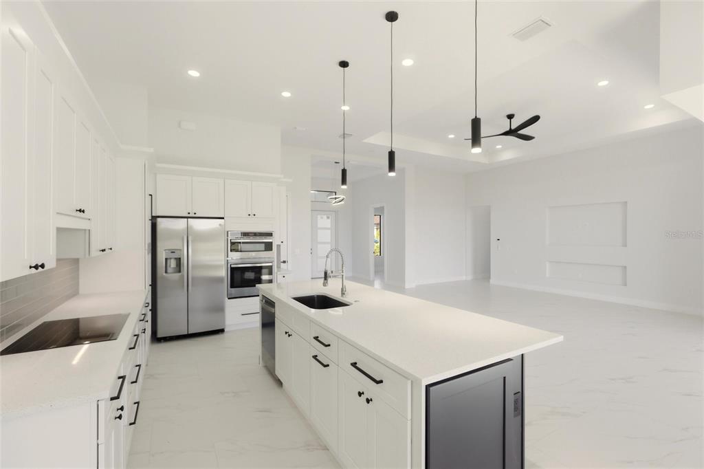 17 Long Meadow Road Rotonda West, FL 33947 - Photo 14 of 37 a kitchen with white cabinets and stainless steel appliances