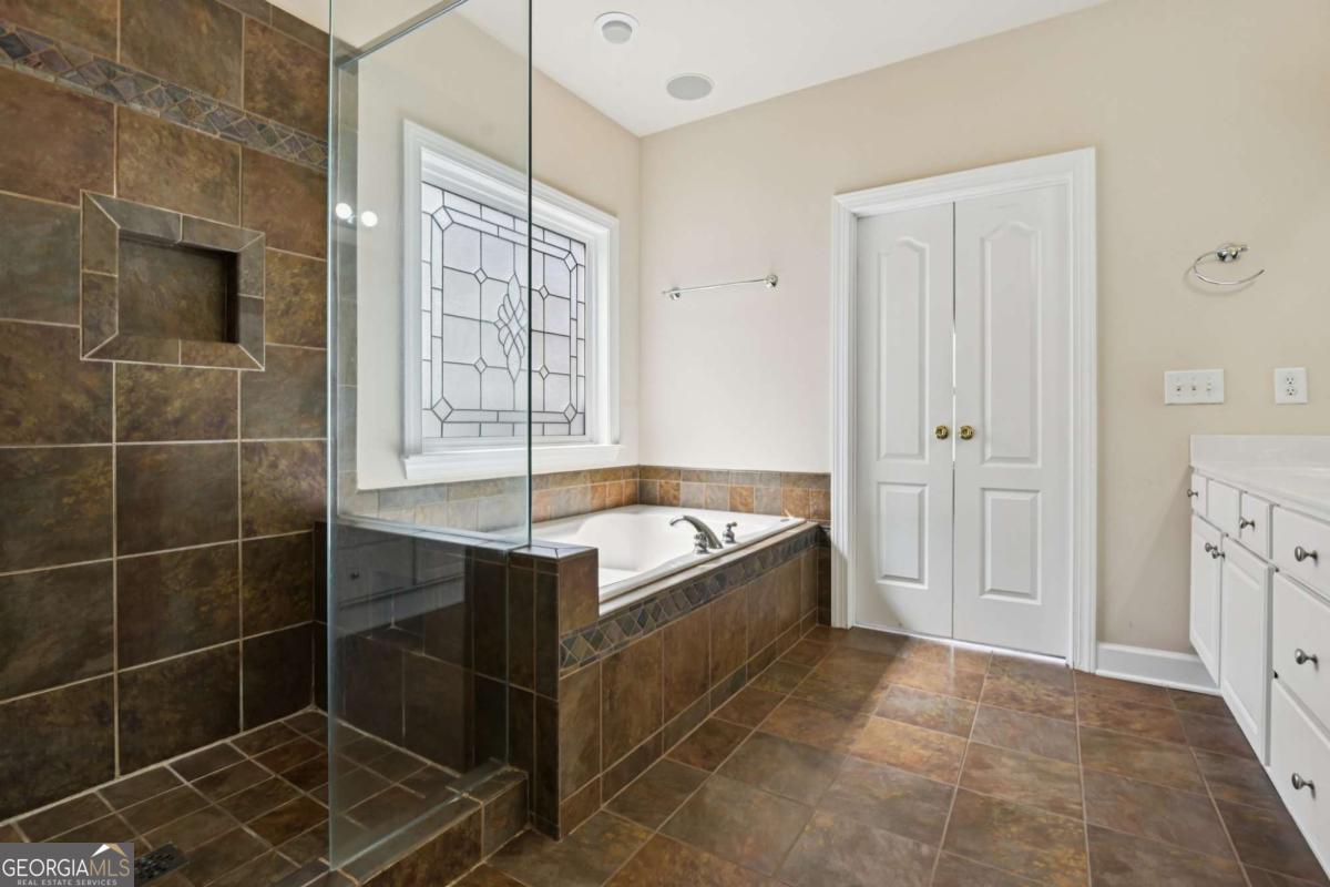 3180 The Commons Drive Cumming, GA 30041 - Photo 27 of 84 a bathroom with a tub shower and sink
