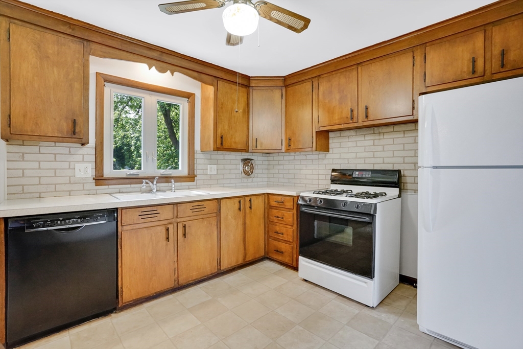 1133 Burnett Road Chicopee, MA 01020 - Photo 11 of 40 a kitchen with stainless steel appliances granite countertop a stove a sink and a refrigerator