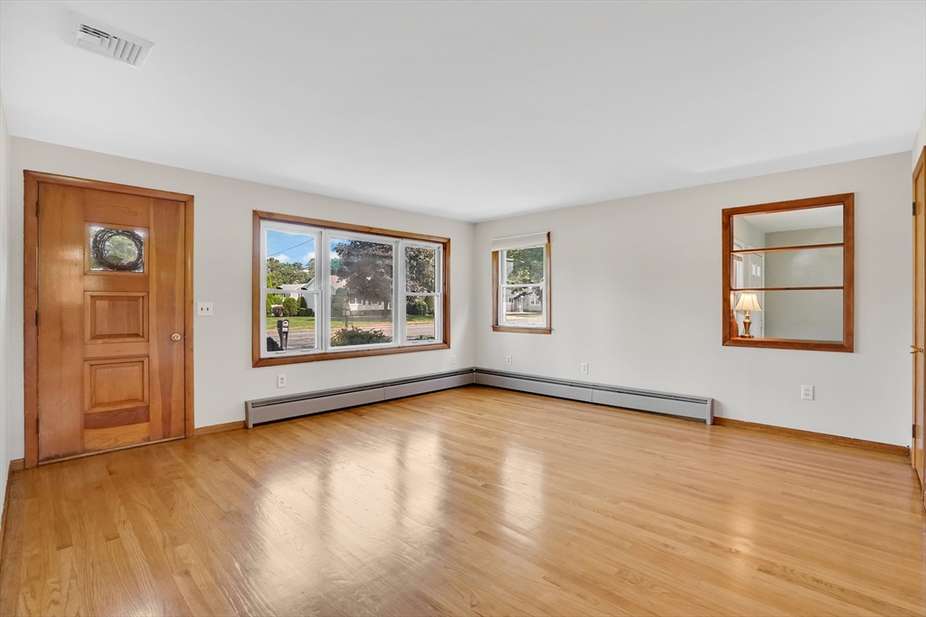 1133 Burnett Road Chicopee, MA 01020 - Photo 14 of 40 a view of an empty room with window and wooden floor