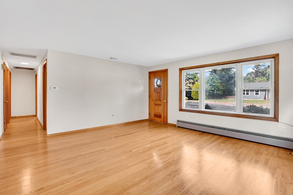 1133 Burnett Road Chicopee, MA 01020 - Photo 15 of 40 a view of an empty room with wooden floor and a window