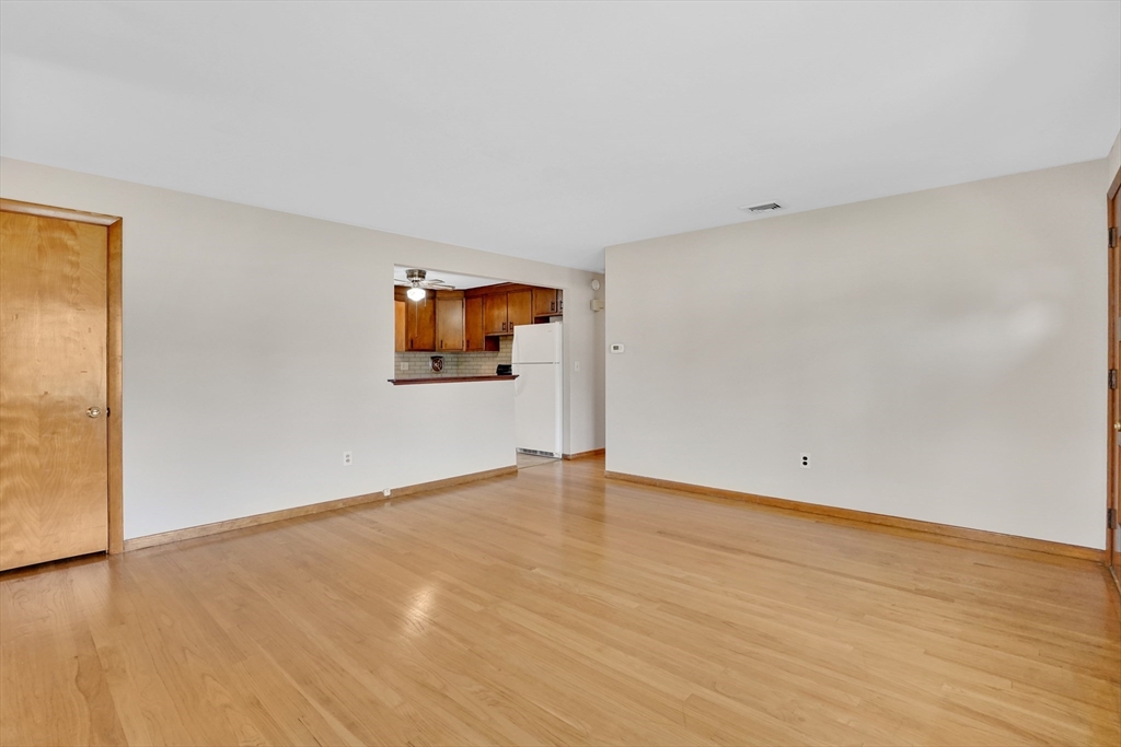 1133 Burnett Road Chicopee, MA 01020 - Photo 16 of 40 a view of an empty room with wooden floor and a window