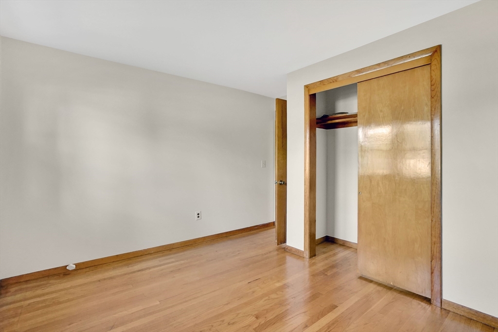 1133 Burnett Road Chicopee, MA 01020 - Photo 19 of 40 an empty room with wooden floor and a window