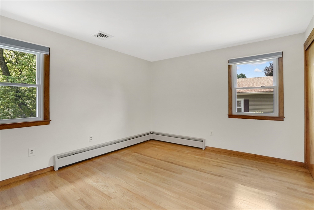 1133 Burnett Road Chicopee, MA 01020 - Photo 21 of 40 a view of an empty room with wooden floor and a window