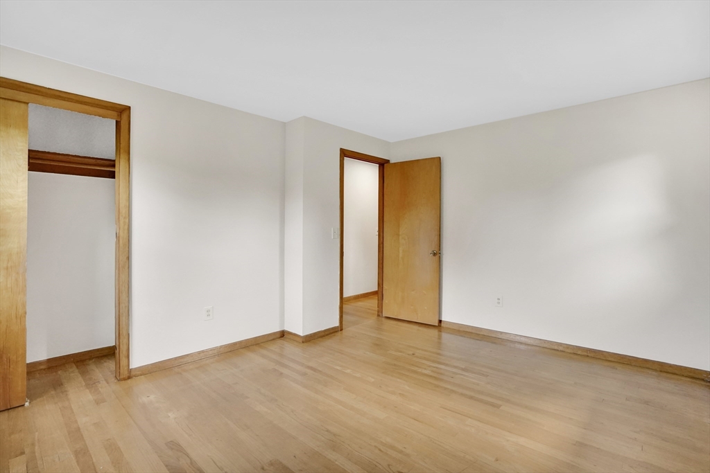 1133 Burnett Road Chicopee, MA 01020 - Photo 22 of 40 a view of an empty room with wooden floor and a window