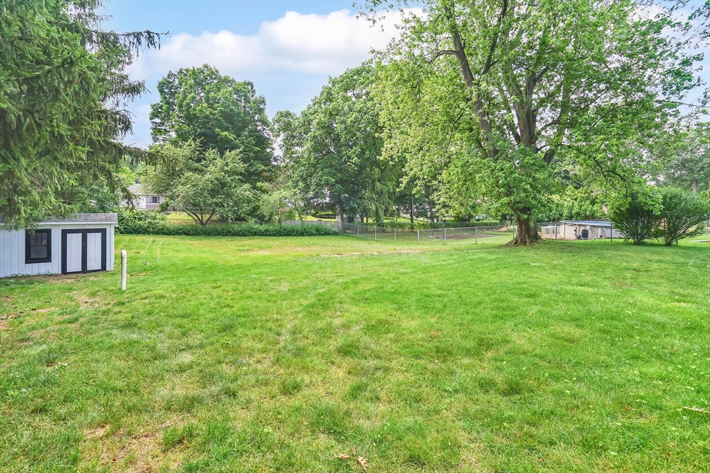 1133 Burnett Road Chicopee, MA 01020 - Photo 5 of 40 a view of a big yard with a house in the background