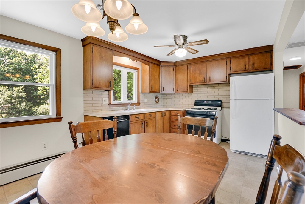 1133 Burnett Road Chicopee, MA 01020 - Photo 9 of 40 a kitchen with stainless steel appliances a table chairs and refrigerator