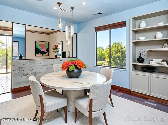 a dining room with furniture and a floor to ceiling window