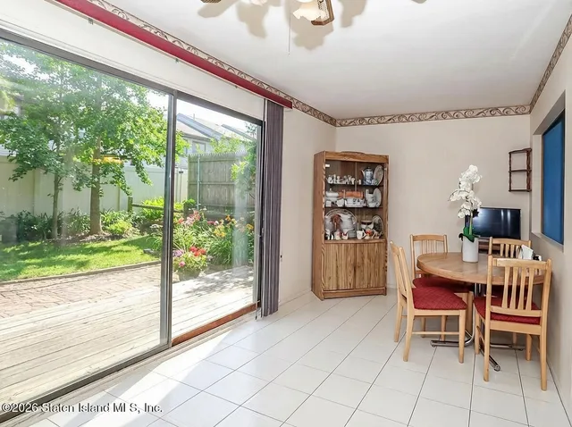a dining room with furniture and a floor to ceiling window