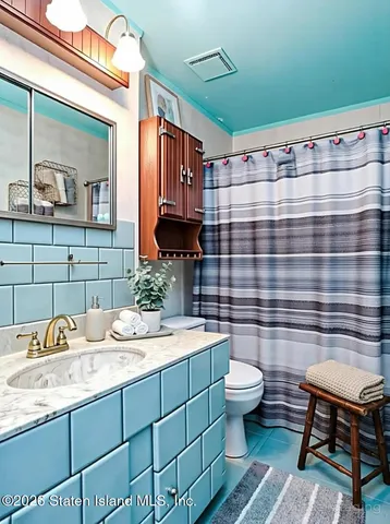 a bathroom with a sink a toilet and mirror