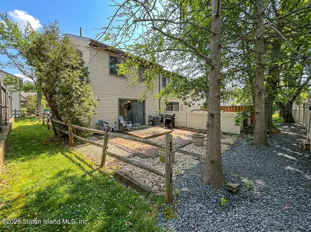 a view of a house with backyard and a tree