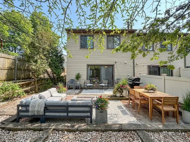a view of a patio with couches table and chairs with wooden fence and floor