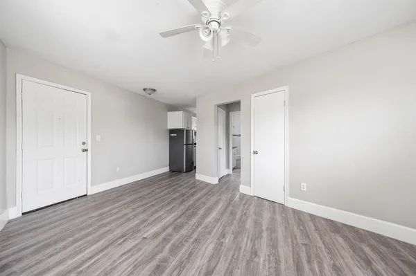 a view of an empty room with wooden floor