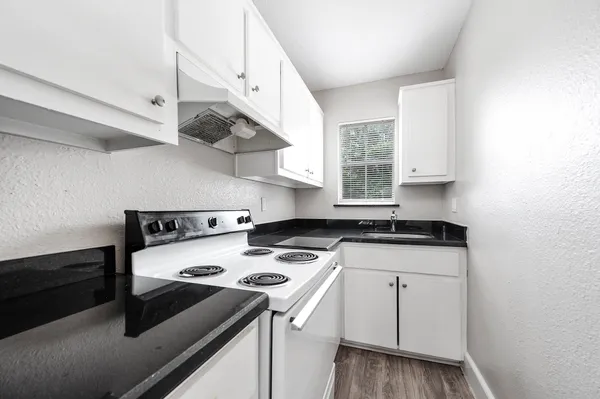 a kitchen with a sink a stove and cabinets