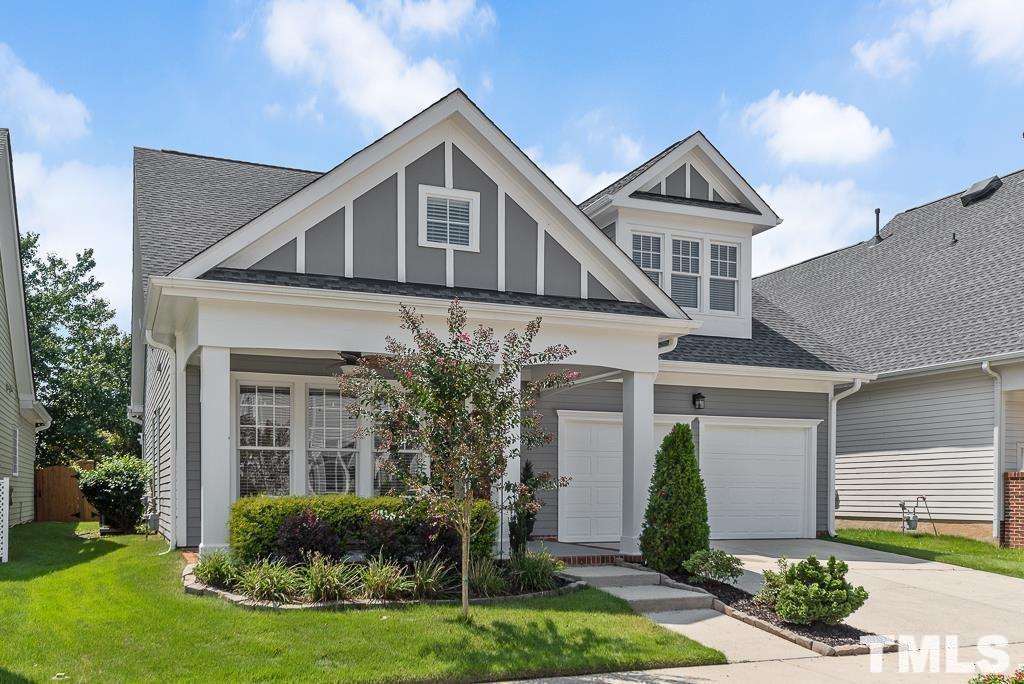 a front view of a house with a yard and potted plants