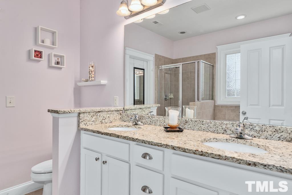 216 Frontgate Drive Cary, NC 27519 - Photo 19 of 26 a bathroom with a granite countertop sink and a mirror