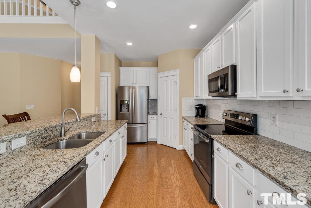 216 Frontgate Drive Cary, NC 27519 - Photo 8 of 26 a spacious kitchen with stainless steel appliances granite countertop a sink stove and refrigerator