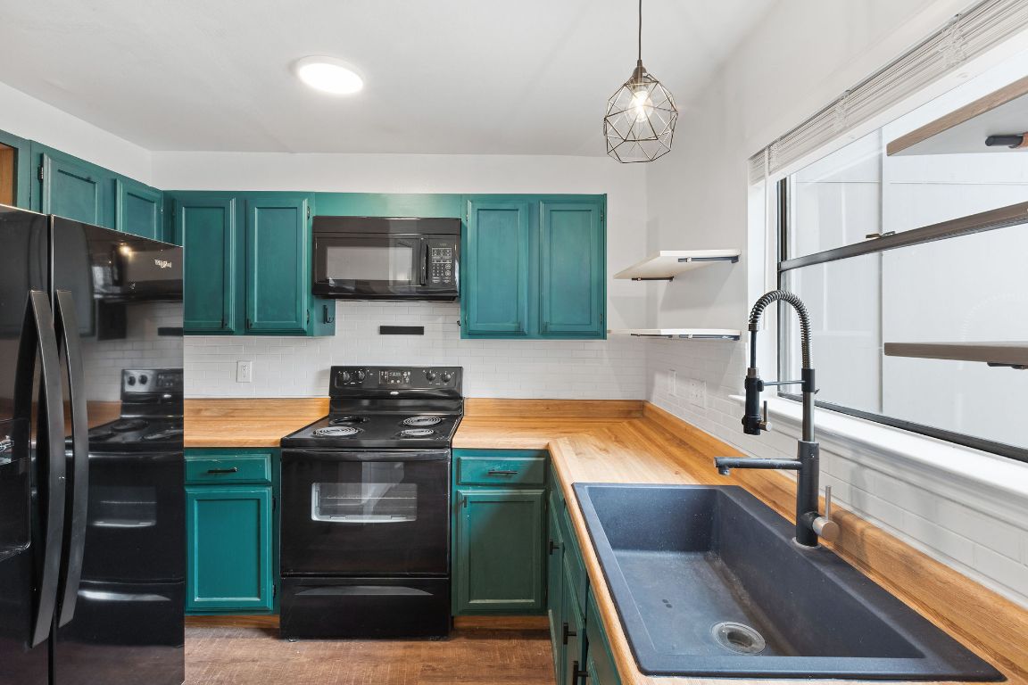 1712 Timber Ridge Road Austin, TX 78741 - Photo 13 of 35 a kitchen with a refrigerator and a sink