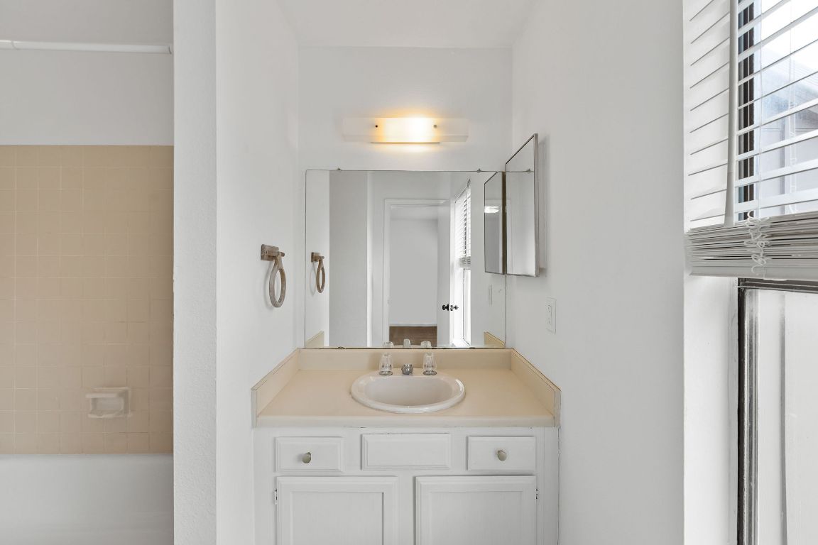 1712 Timber Ridge Road Austin, TX 78741 - Photo 22 of 35 a bathroom with a sink and a mirror