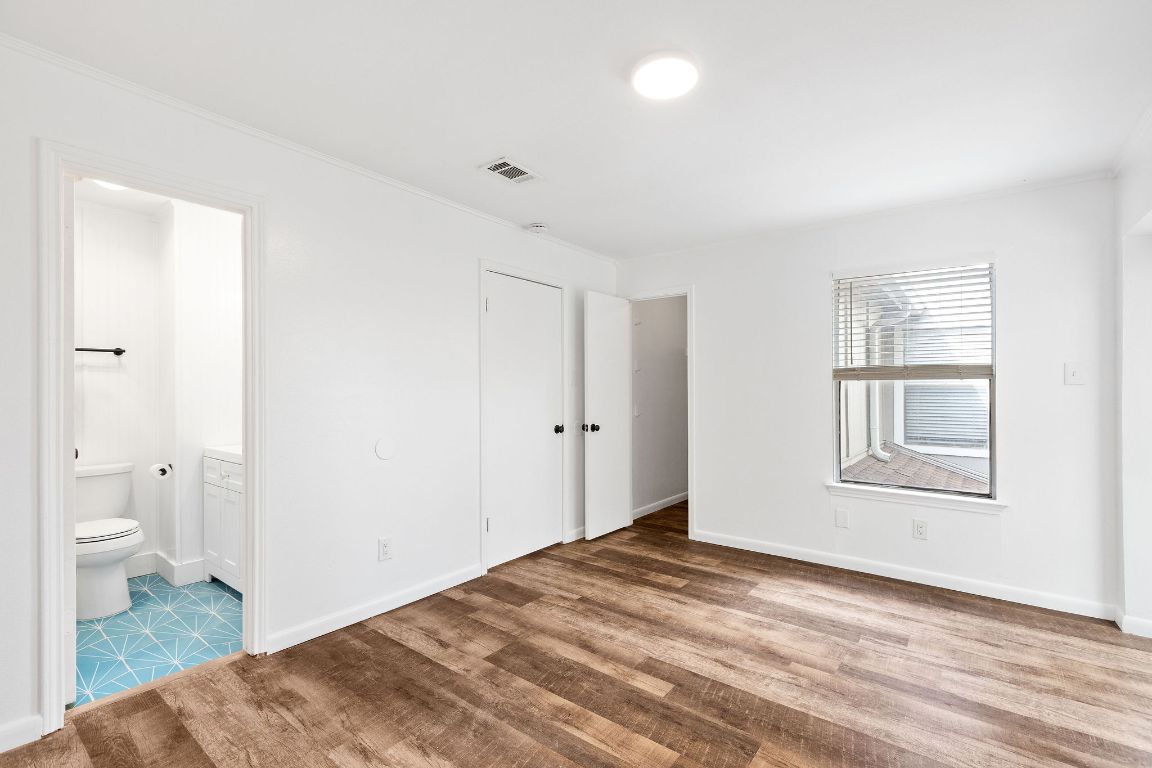 1712 Timber Ridge Road Austin, TX 78741 - Photo 27 of 35 a view of a bedroom with wooden floor and a bathroom