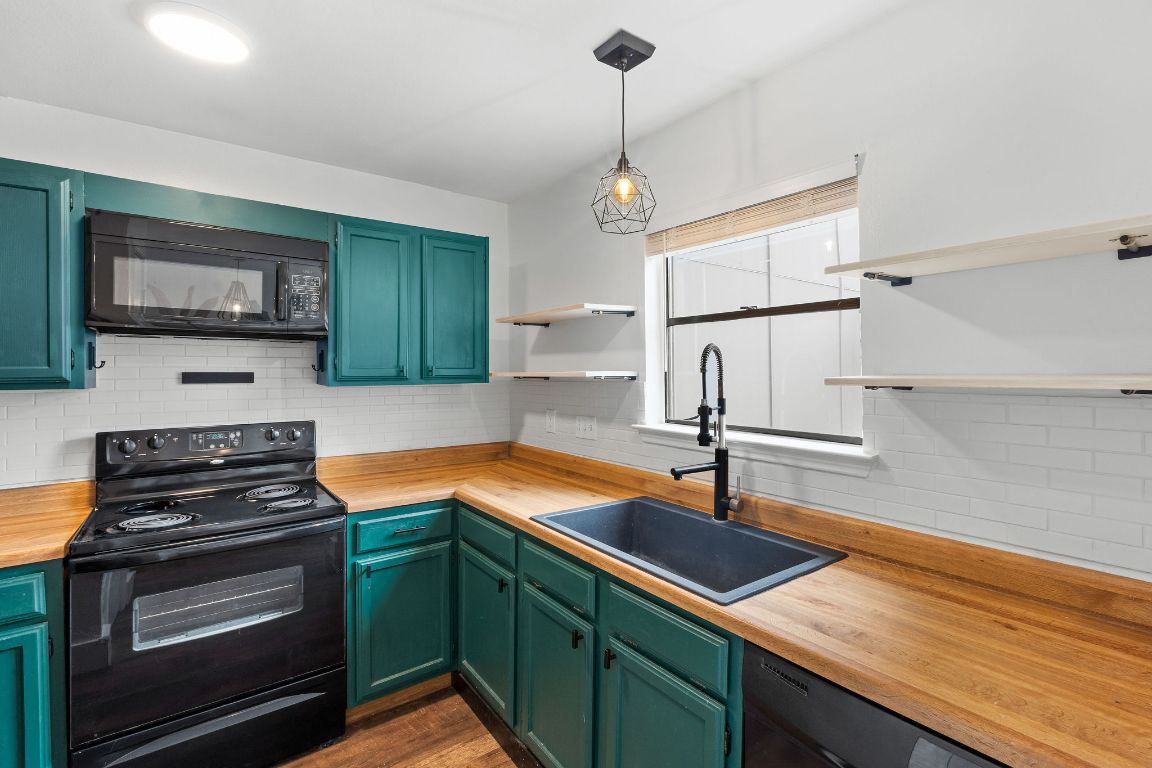 1712 Timber Ridge Road Austin, TX 78741 - Photo 8 of 35 a kitchen with stainless steel appliances granite countertop a sink a stove and cabinets