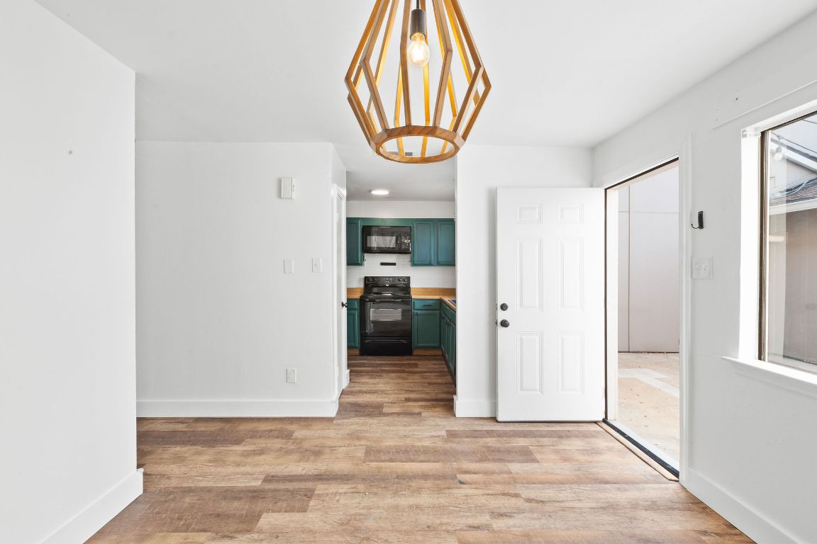 1712 Timber Ridge Road Austin, TX 78741 - Photo 9 of 35 a view of a hallway with wooden floor and a dining room