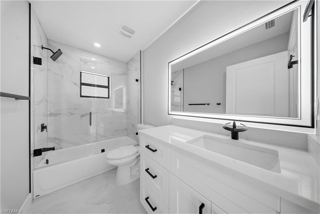3406 25th Street Southwest Lehigh Acres, FL 33976 - Photo 20 of 44 a bathroom with a bathtub shower sink mirror and toilet
