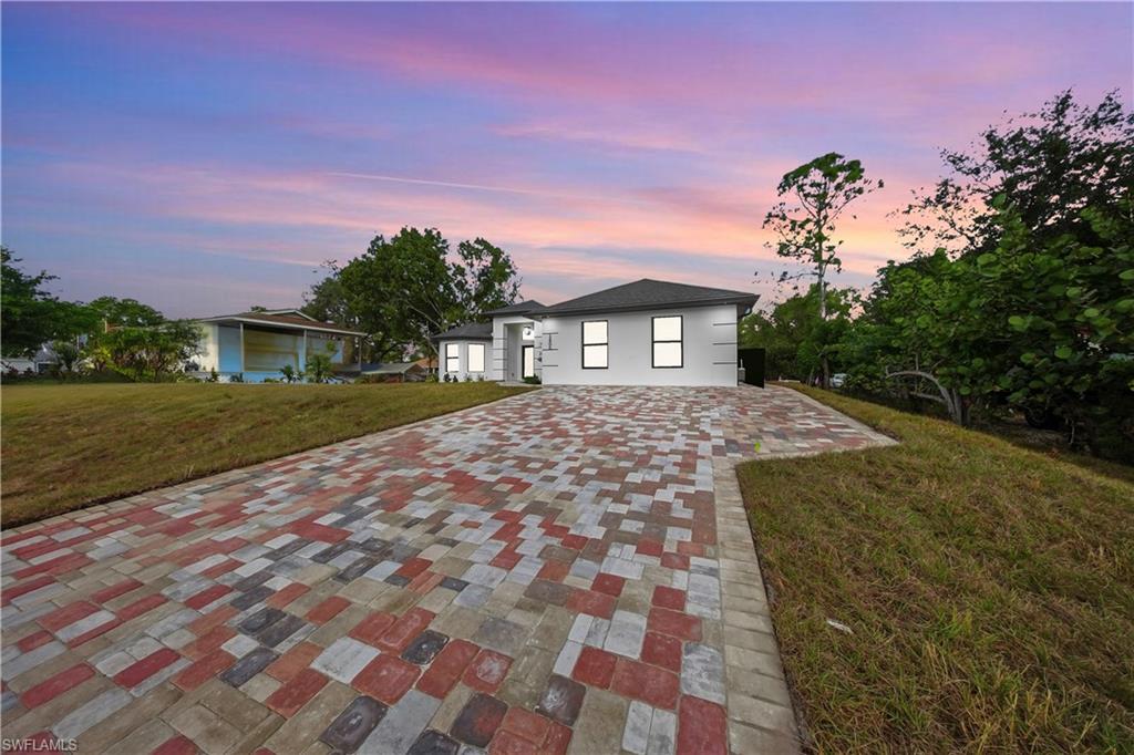 3406 25th Street Southwest Lehigh Acres, FL 33976 - Photo 3 of 44 a front view of a house with a yard