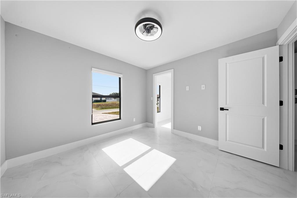 3406 25th Street Southwest Lehigh Acres, FL 33976 - Photo 39 of 44 a view of an empty room with window and hardwood floor
