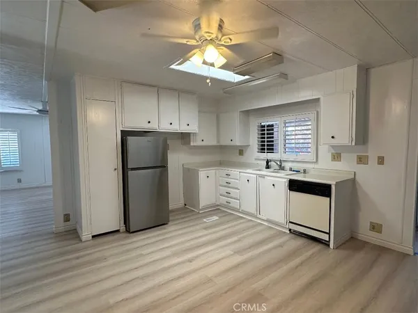 a kitchen with granite countertop white cabinets and white appliances